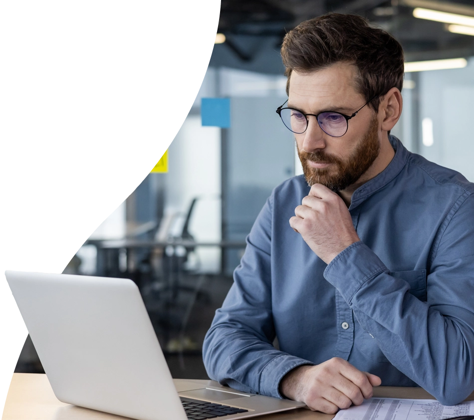 Ein Mann überlegt am Laptop, ob er sich beim PIM-System für Cloud oder On-Premise entscheiden soll