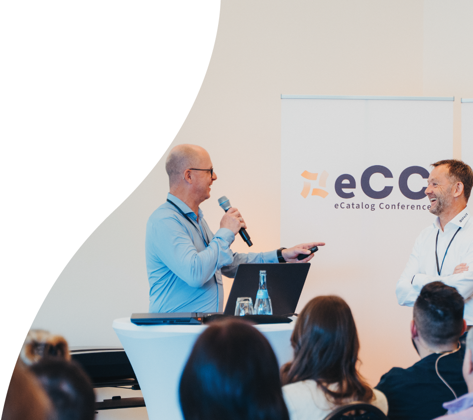 Herby Tessadri, Head of Sales at crossbase, speaks to the audience with microphone in hand. He points with his left hand to Achim Angel from 4PACE, who is giving a presentation together with him. Both laugh and look directly at each other.