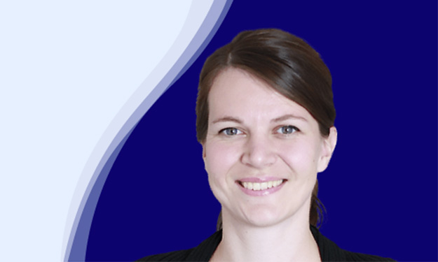 Jasmin Nesbigall de oneworld sourit en regardant la caméra. Elle a les cheveux bruns avec une raie sur le côté, attachés dans la nuque. Elle porte un haut noir. L'arrière-plan est bleu foncé avec une ligne incurvée blanche et bleu clair en forme de vague sur le côté gauche.